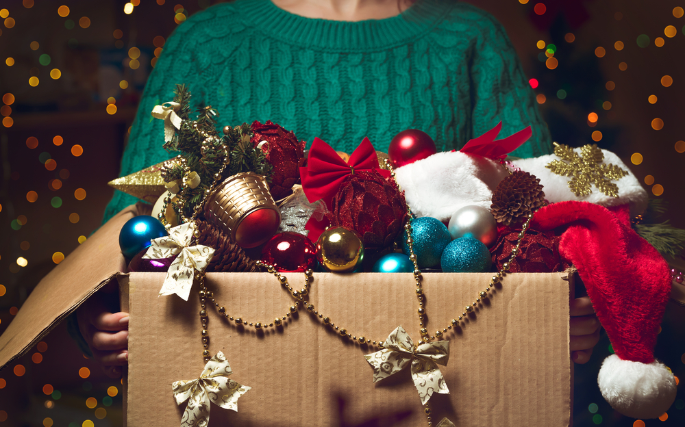 woman holds Christmas decorations